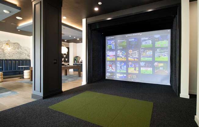 A room with a green carpet and a screen with images on it.