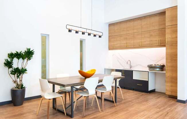 A modern dining room with a wooden table and chairs.
