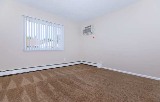 a bedroom with a carpeted floor and a large window