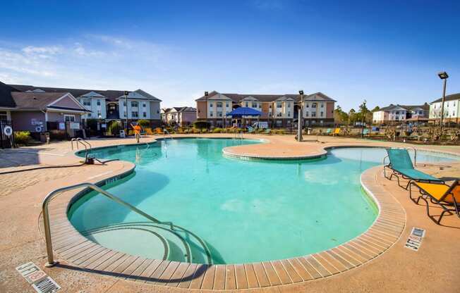 a large swimming pool with houses in the background