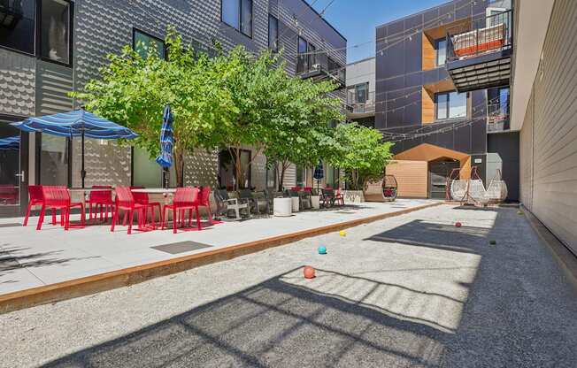 a patio with tables and chairs and trees