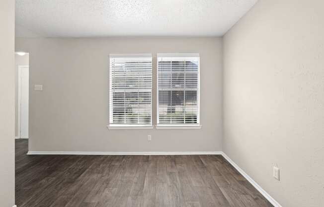 a bedroom with a large window and hardwood floors