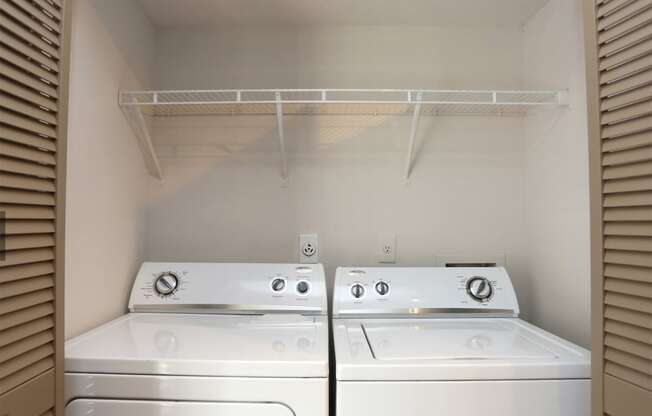 an empty laundry room with two washes and a dryer