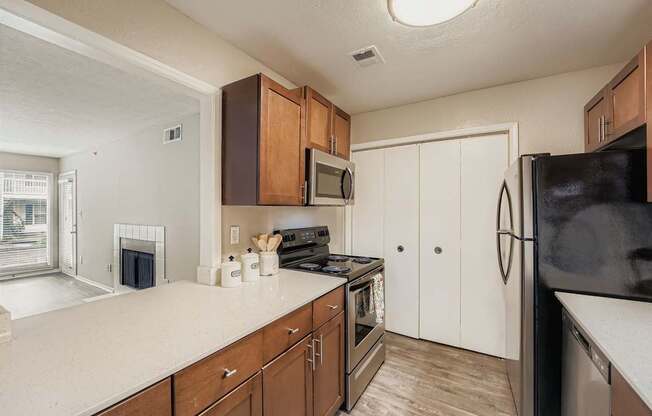 A kitchen with brown cabinets and a black refrigerator.