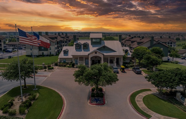 an aerial view of a building with an flag at sunset