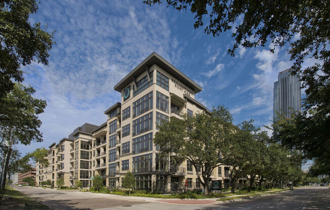 a large apartment building on a city street with trees