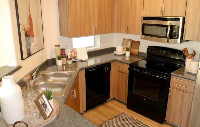A kitchen with black appliances and wooden cabinets.