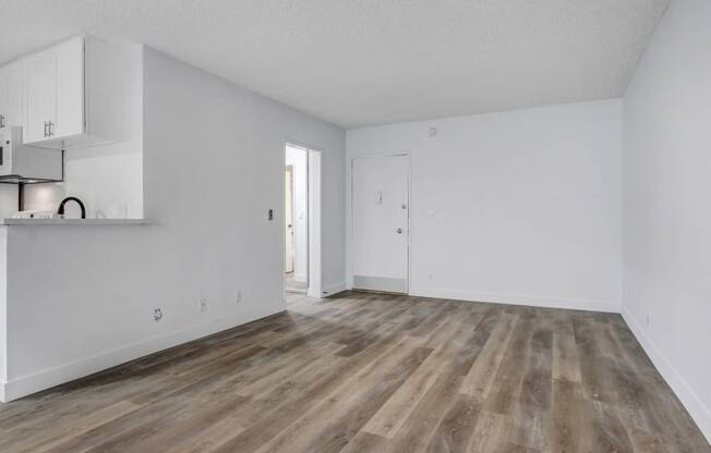 a bedroom with hardwood floors and white walls