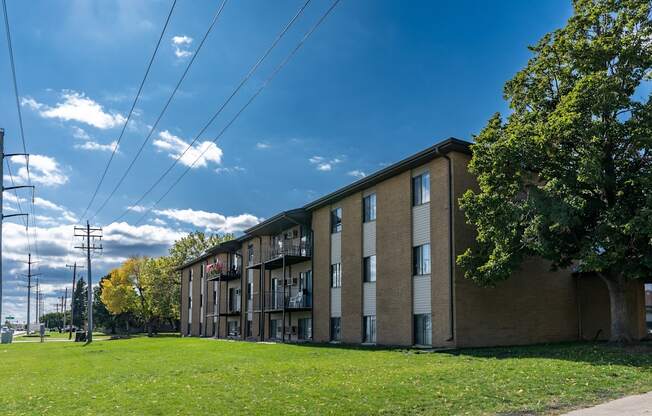 a large brick apartment building with a green grass in front at France, North Dakota