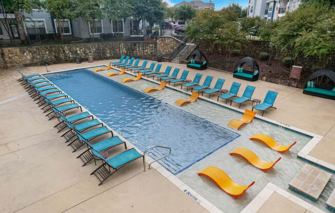 a swimming pool with lounge chairs and chairs around it