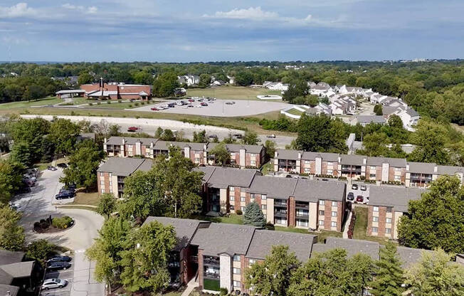 an aerial view of an apartment complex with a parking lot