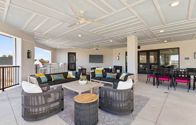 A modern outdoor living space with a white ceiling fan and a black and white striped rug.