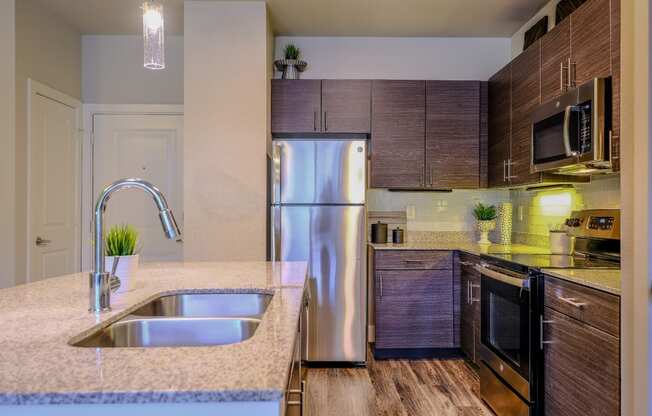 spacious kitchen with stainless steel appliances and granite counter tops at The Allure luxury apartments