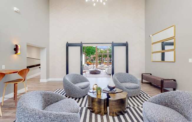 a living room with chairs and a table and a sliding glass door