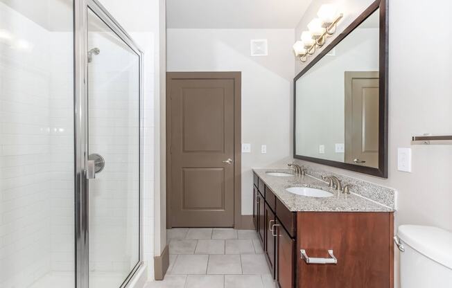 a bathroom with a shower and a sink and a mirror