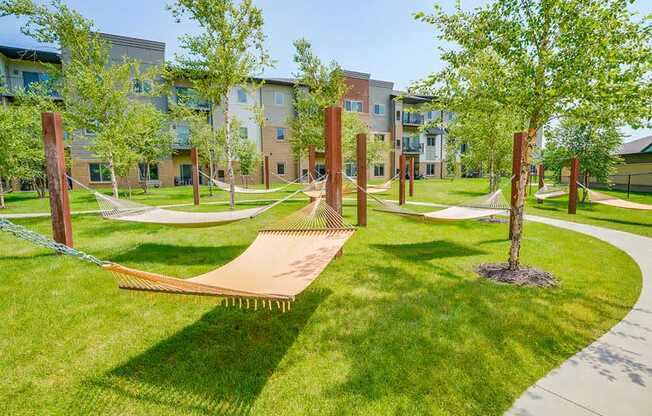 A hammock garden with several cloth-style hammocks and trees for shade.