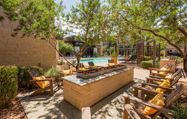 A sunny backyard with a hot tub and chairs.
