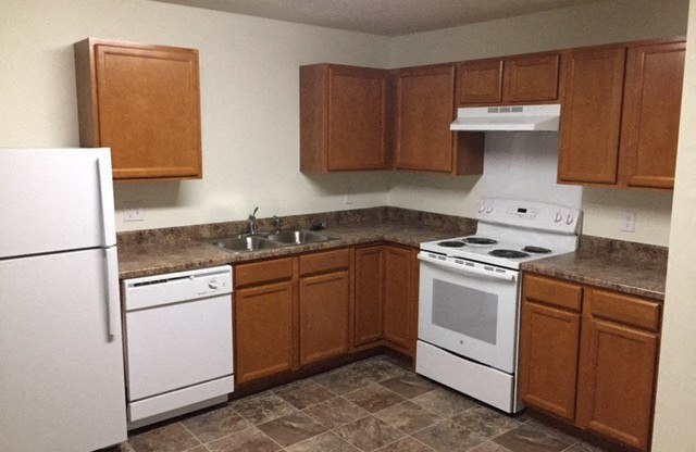 a kitchen with white appliances and brown cabinets