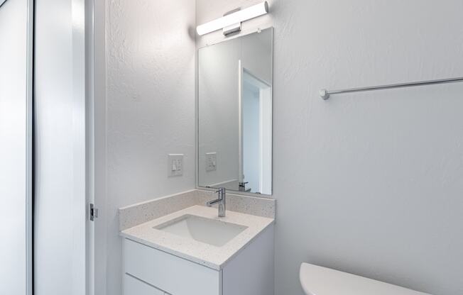 an empty bathroom with a sink and a mirror at Avenue Two Apartments, Redwood City  , CA 94063