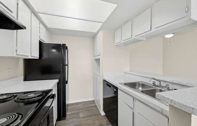 A kitchen with black appliances and white cabinets at Westdale Pointe in Austin, TX