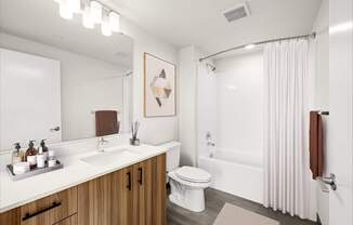 A bathroom with a white sink, toilet, and bathtub.