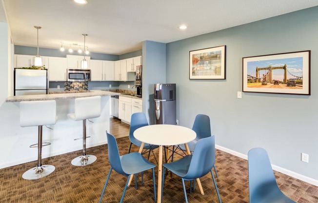 a dining room with a kitchen with a table and chairs