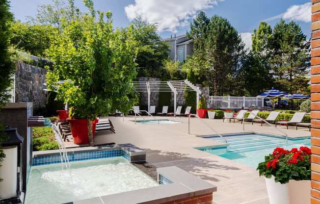 our apartments have a large pool and spa with chairs and plants at Residences at Stevens Pond, Massachusetts, 01906