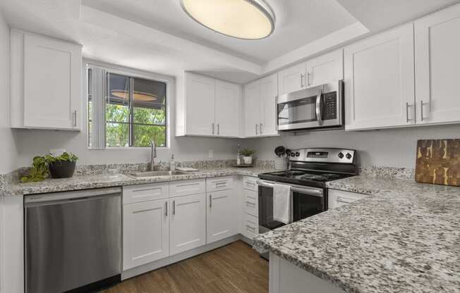 a kitchen with granite counter tops and white cabinets at Vaseo Apartments, Phoenix, 85022