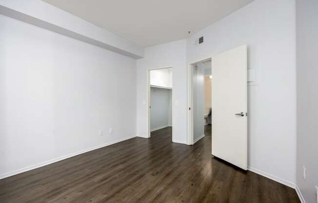 an empty living room with white walls and wood floors