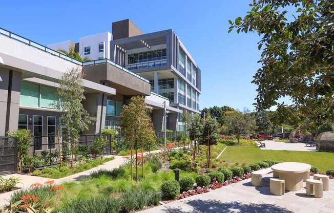 a view of the building with a garden and benches