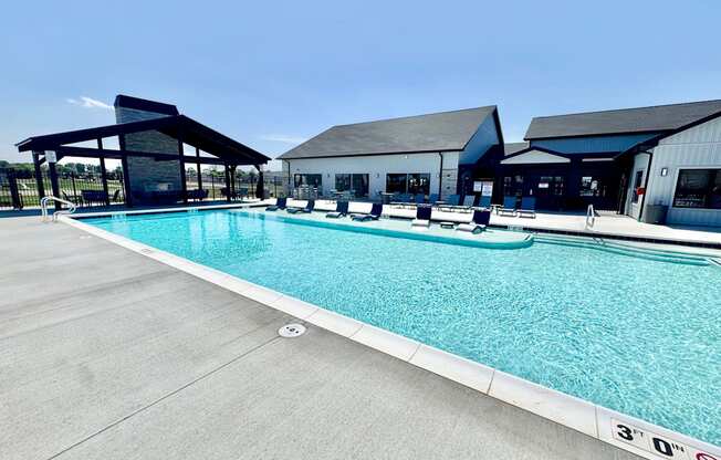 A large outdoor swimming pool with a building in the background.
