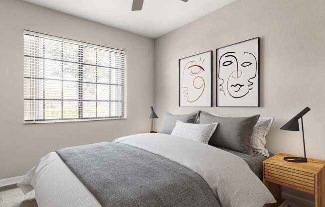 A bedroom with a bed, nightstand, and two framed artworks on the wall.