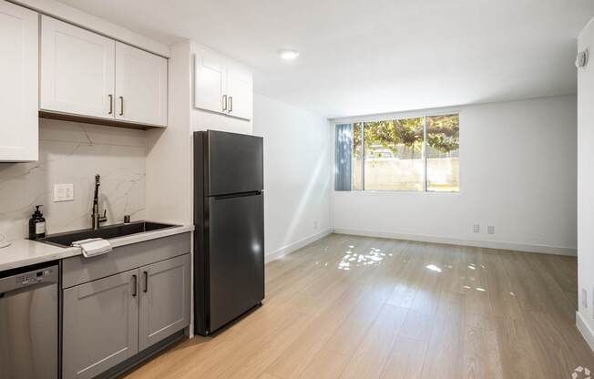 an empty kitchen with stainless steel appliances and a window