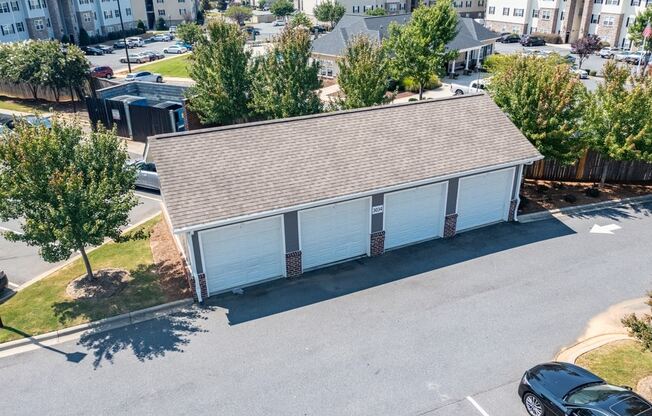 an aerial view of a white building with blue garage doors