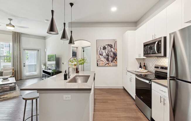 A modern kitchen with a large island and stainless steel appliances.