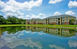 a large pond sits in front of an apartment complex