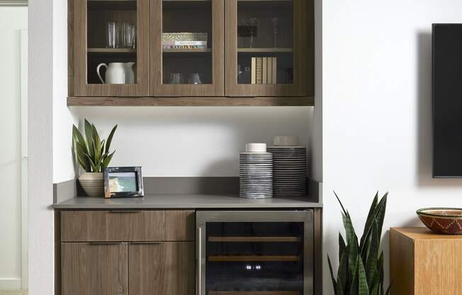 a kitchen with wooden cabinets and a plant next to a tv