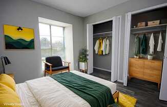 A bedroom with a bed, chair, and wardrobe.
