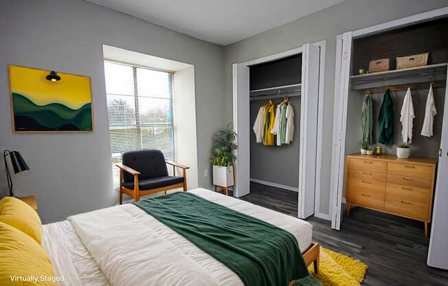 A bedroom with a bed, chair, and wardrobe.