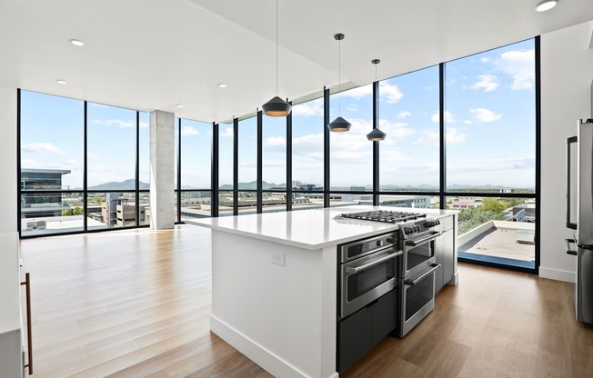 A modern kitchen with a large island and stainless steel appliances.