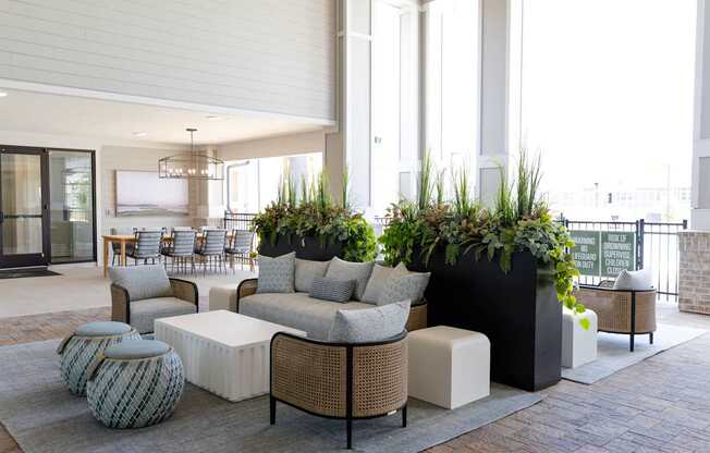 A modern outdoor seating area with a variety of furniture and plants.
