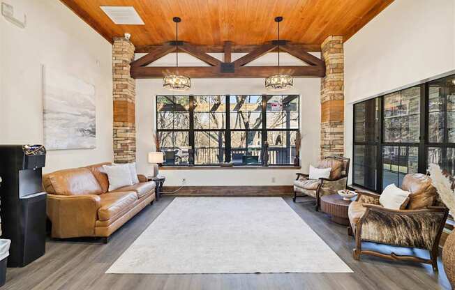 A living room with a brown leather couch and a large window.