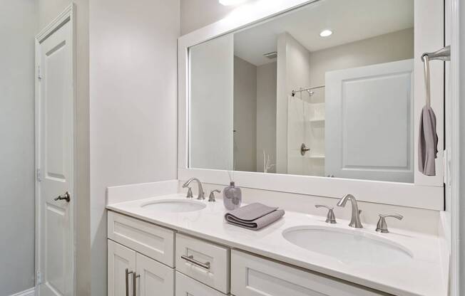 Bathroom with single-sink vanity, mirror, and bright lighting in updated Atlanta apartment.