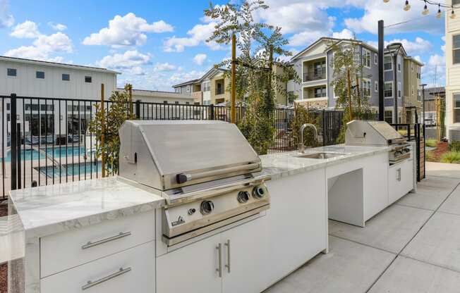Outdoor BBQ area with 2 Grills and Apartment Exteriors at Morgan Ranch Apartments, California, 95037