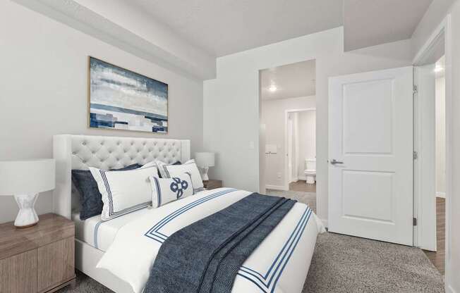 A bedroom with a large bed and a painting on the wall.