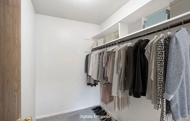 a walk in closet with a rack of clothes at Seville Apartments, Kalamazoo, MI, 49009