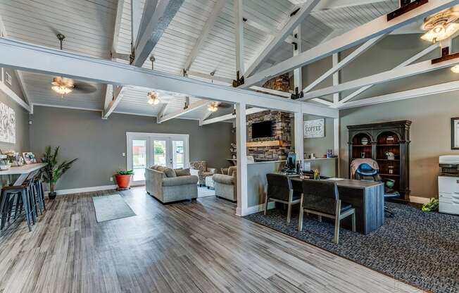 the living room and dining room of a house with wood flooring and exposed ceilings