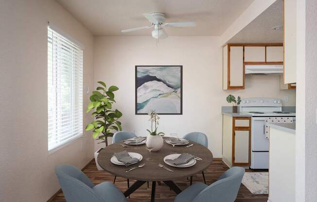 A dining room with a table set for two and a painting on the wall.