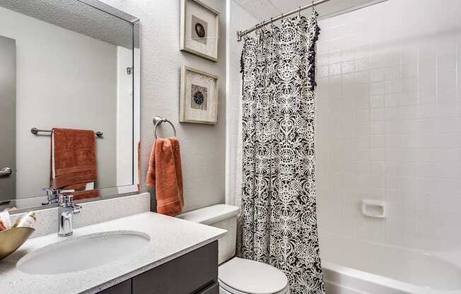 A bathroom with a white sink and a shower curtain.