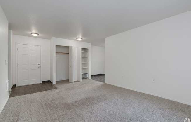 A large, empty room with a carpeted floor and white walls.